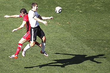 Germany's Miroslav Klose is involved in an aerial duel with Serbia's Dejan Stankovic (left)