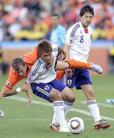 The Netherlands's Rafael van der Vaart (left) and Japan's Yuichi Komano (centre) get into a tangle as they vie for possession