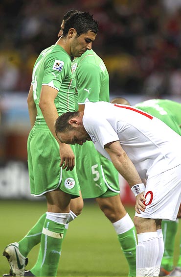 England's Wayne Rooney (right) and Algerian players wear a dejected look after the match