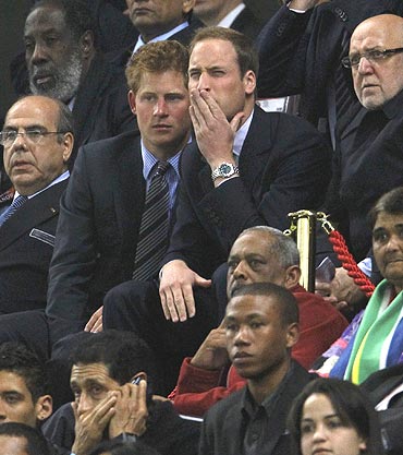 England's Princes William and Harry react during the match