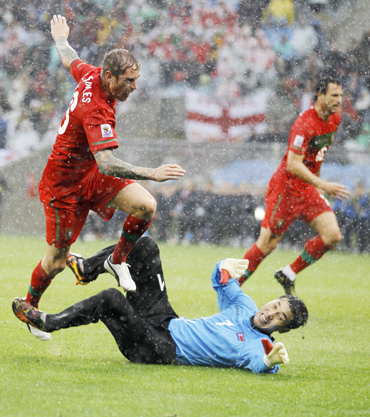 Portugal's Meireles jumps over North Korea's goalkeeper Ri after scoring during a 2010 World Cup Group G soccer match