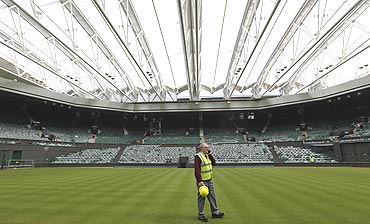 Chief groundsman Eddie Seaward walks underneath the Centre Court retractable roof at the All England Lawn Tennis Club