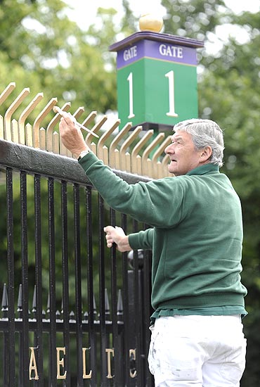 A workman puts the finishing touches to a fence in preparation for the Wimbledon Tennis Championships