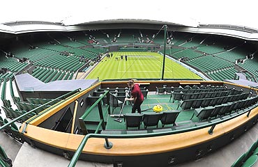 A member of the ground crew vaccums the royal box in preparation for the Wimbledon Tennis Championships