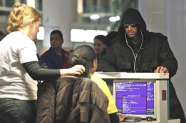 French player Nicolas Anelka (right) waits at the check-in counter as he readies to board a flight to London at the international airport in Cape Town