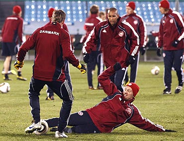 Denmark's Soren Larsen (right) takles teammate Jon Dahl Tomasson (left) during a training session