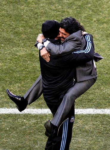 Argentina's coach Diego Maradona (right) celebrates his team's third goal with a member of his coaching staff