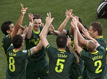 Slovenia's Robert Koren (No. 8) celebrates with team mates after scoring against Algeria