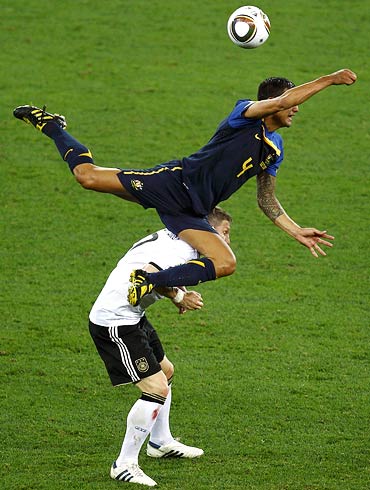 Australian midfielder Tim Cahill (top) jumps for the ball over Germany's Bastian Schweinsteiger