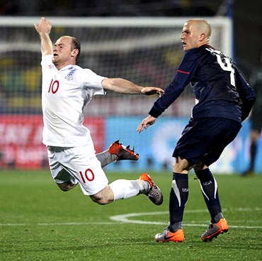 Wayne Rooney (left) falls after clashing with Michael Bradley of the US