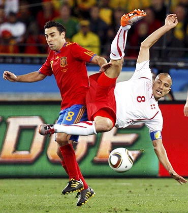 Xavi (left) fights for the ball with Switzerland's Gokhan Inler
