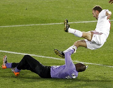 Denmark's Dennis Rommedahl (right) takes a tumble a challenge from Cameroon goalkeeper Hamidou Souleymanou