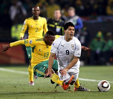 South African Kagisho Dikgacoi (left) and Uruguay's Luis Suarez collide