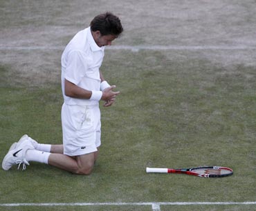 France's Nicolas Mahut kneels on the ground after dropping his racquet during the fifth set