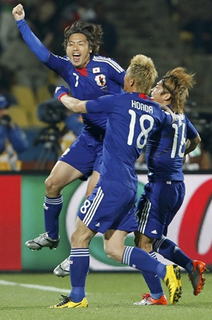 Japan's Yasuhito Endo celebrates with team mates Keisuke Honda and Yoshito Okubo after scoring