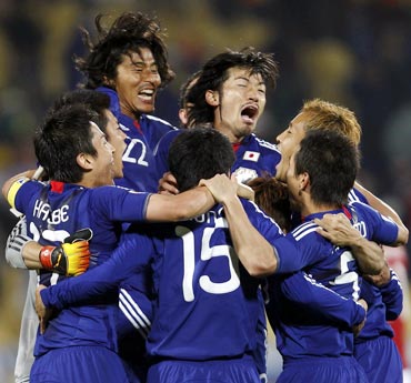 Japan players celebrate after winning their match against Denmark