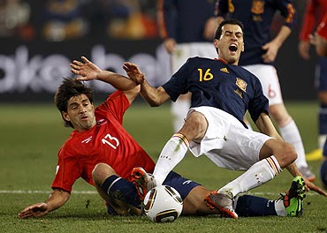 Chile's Marco Estrada (left) challenges Spain's Sergio Busquets during their match
