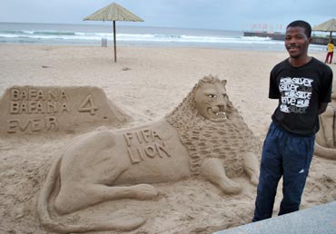 A sand artist shows off his creation
