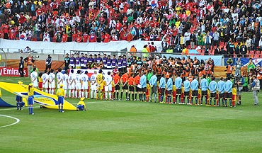 Players stand in respect as the national anthems are played out
