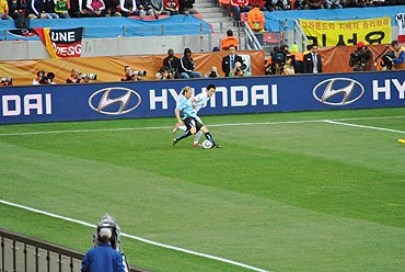 Diego Forlan tries to cuts past a South Korean defender