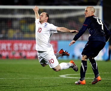 Wayne Rooney is tackled by USA's Michael Bradley
