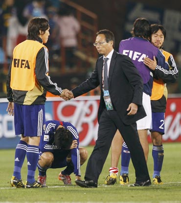 Japan's coach Takeshi Okada consoles his players