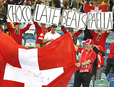 Switzerland's fans hold a national flag and banners as they celebrate after their win against Spain