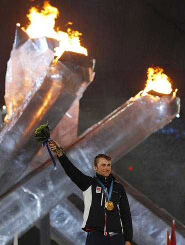 Gold medalist Northug waves during the medal ceremony for the men's 50k cross country
