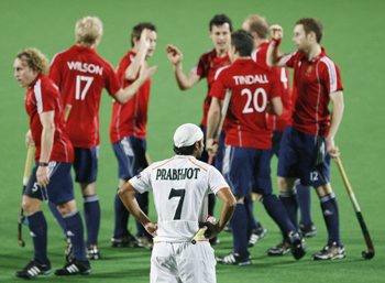 England's players celebrate their first goal as India's Singh watches during their match at the men's Hockey World Cup