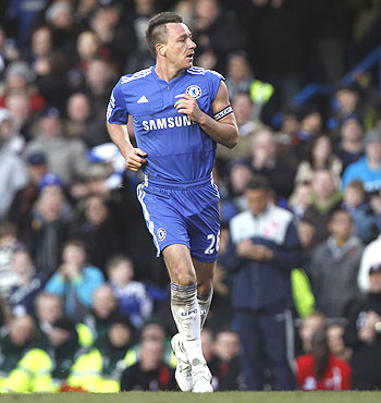 John Terry shows off his captain's armband as he celebrates after scoring