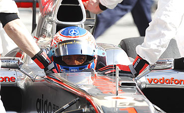 McLaren Formula One driver Jenson Button of Britain gets a pit service