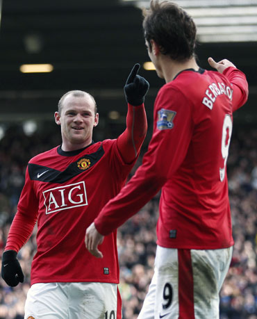 Rooney celebrates with Berbatov after scoring a goal