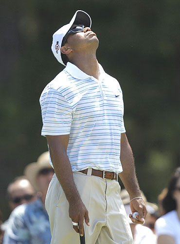 Tiger Woods stretches his neck