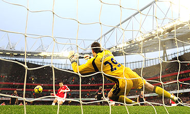 Arsenal's Cesc Fabregas (left) takes a penalty kick against Stoke City's goalkeeper Thomas Sorensen