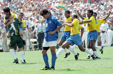 Brazilian striker Bebeto leaps into the arms of goalkeeper Claudio Taffarel as Italy's Roberto Baggio stares at the ground after missing the penalty