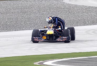 Red Bull's Sebastian Vettel of Germany exits his car after colliding with team-mate Mark Webber