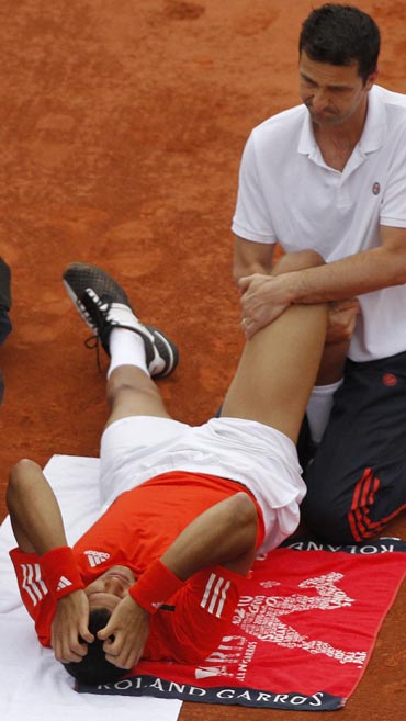 Jo-Wilfried Tsonga receives medical attention during his match against Mikhail Youzhny