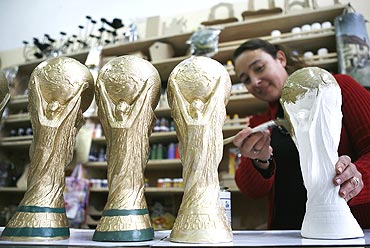 Denise Riquelme, the owner of a shop of handmade crafts, paints replicas of the World Cup trophy in Valparaiso city, near Santiago, Chile