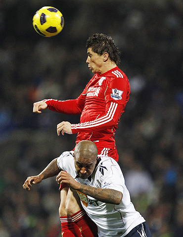 Bolton Wanderers' Zat Knight challenges Liverpool's Fernando Torres (top) during their match on Sunday