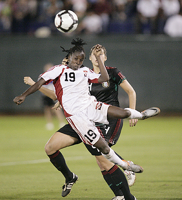 Kennya Cordner of Trinidad and Tobago (left) jumps for the ball over Natalie Vinti of Mexico during the CONCACAF Women's World Cup qualifying match at the Beto Avila stadium in Cancun on Sunday