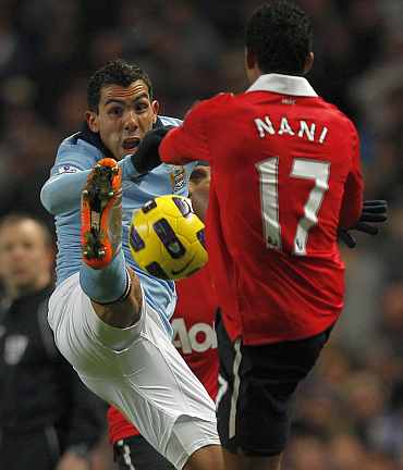 Man City's Carlos Tevez fights for the ball with Man United's Nani
