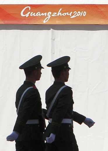 Security personnel walk in front of the stadium