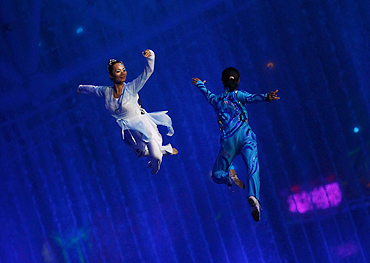 Performers are suspended from a harness during a performance at the opening ceremony