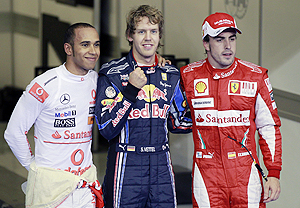Sebastian Vettel, Fernando Alonso and Lewis Hamilton pose after the F1 qualifying race in Abu Dhabi on Saturday