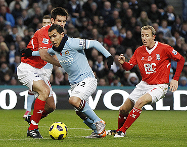 Manchester City's Tevez is challenged by Birmingham City's Scott Dann and Lee Bowyer on Saturday
