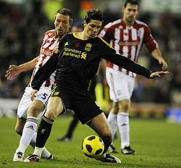 Stoke City's Danny Collins challenges Liverpool's Fernando Torres during their match on Saturday