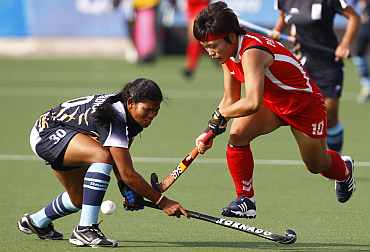 South Korea's Park battles for the ball with India's Pradhan during their hockey game
