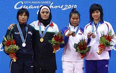 Sandhyarani Devi (left) stands on the podium after winning her silver in Wushu