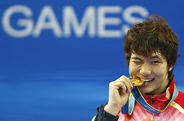 South Korea's Heo Jung-nyoung bites his gold medal after the men's taekwondo 87kg final on Thursday
