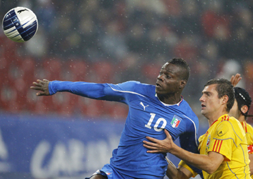 Italy's Mario Balotelli (L) and Romania's Gabriel Tamas fight for the ball during their friendly soccer match in Klagenfurt